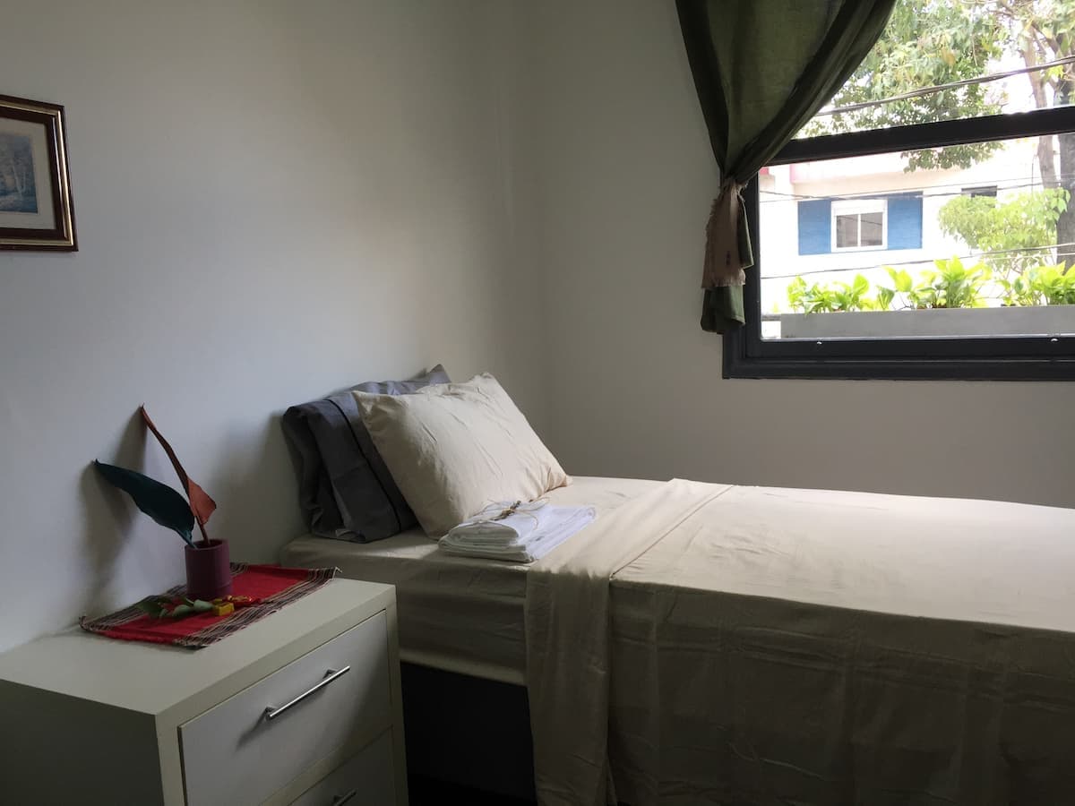 Cama de solteiro e janela do Quarto 13