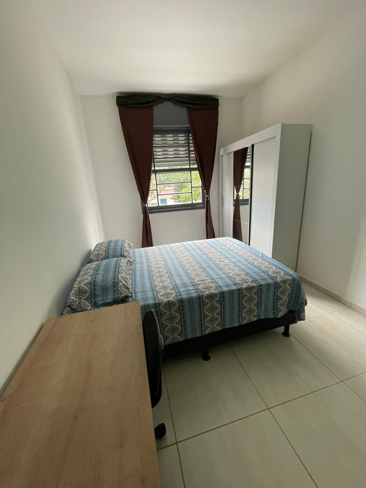 Suíte 25: cama de casal e mesa de trabalho